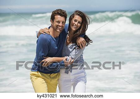 Stock Image - Couple enjoying on the beach. Fotosearch