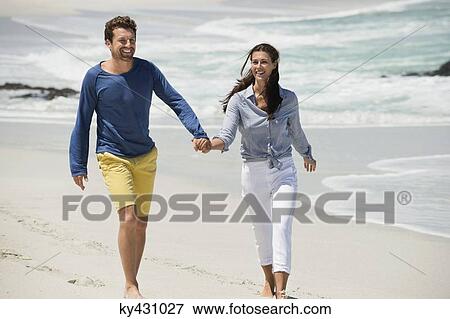 Stock Photo - Couple enjoying on the beach. Fotosearch