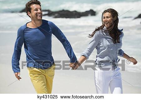 Stock Photography - Couple enjoying on the beach. Fotosearch
