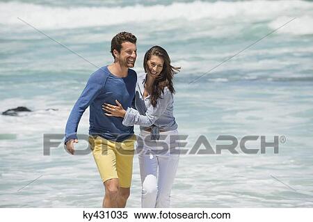 Stock Photography - Couple enjoying on the beach. Fotosearch