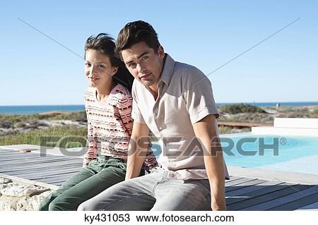 Couple sitting on a boardwalk on the beach View Large Photo Image Stock Image - Couple sitting on a boardwalk on the beach. Fotosearch