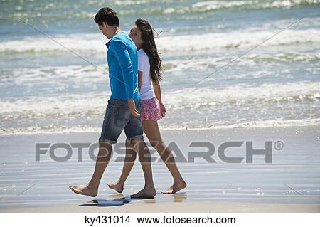 Picture - Couple walking on the beach. Fotosearch