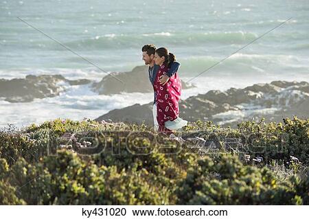 Stock Image - Couple walking on the beach. Fotosearch