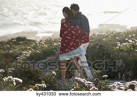 Stock Image - Couple walking on the beach. Fotosearch