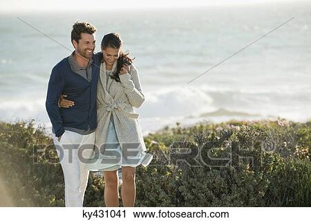 Stock Image - Couple walking on the beach. Fotosearch