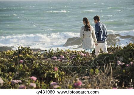 Couple walking on the beach View Large Photo Image Stock Image - Couple walking on the beach. Fotosearch