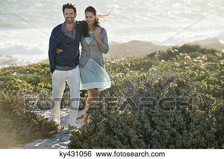 Stock Photograph - Couple walking on the beach. Fotosearch