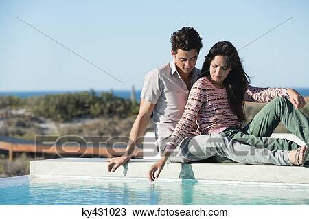 Romantic couple sitting at the poolside View Large Photo Image Stock Image - Romantic couple sitting at the poolside. Fotosearch