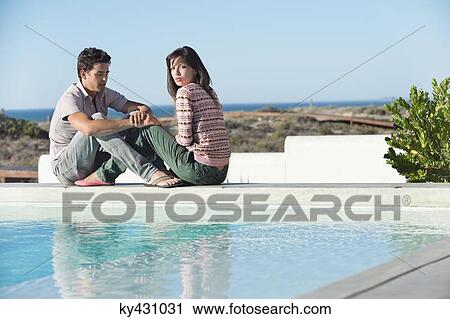 Romantic couple sitting at the poolside on the beach View Large Photo Image Stock Image - Romantic couple sitting at the poolside on the beach. Fotosearch
