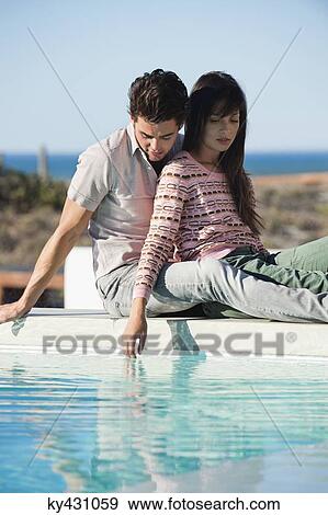 Romantic couple sitting at the poolside View Large Photo Image Stock Photo - Romantic couple sitting at the poolside. Fotosearch