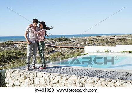 Romantic couple standing on a boardwalk on the beach View Large Photo Image Stock Photo - Romantic couple standing on a boardwalk on the beach. Fotosearch