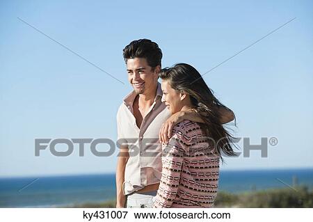 Stock Photo - Romantic couple standing on the beach. Fotosearch