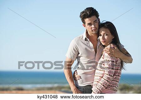 Stock Photo - Romantic couple standing on the beach. Fotosearch