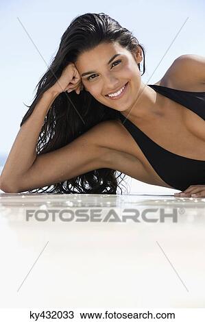 Beautiful woman lying on the beach and smiling View Large Photo Image Stock Image - Beautiful woman lying on the beach and smiling. Fotosearch