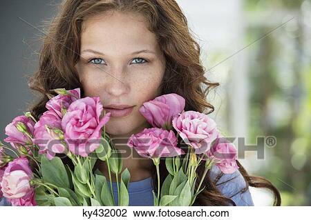 Stock Image - Portrait of a woman holding a bouquet of flowers. Fotosearch