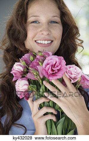 Portrait of a woman holding a bouquet of flowers and smiling View Large Photo Image Stock Photo - Portrait of a woman holding a bouquet of flowers and smiling. Fotosearch