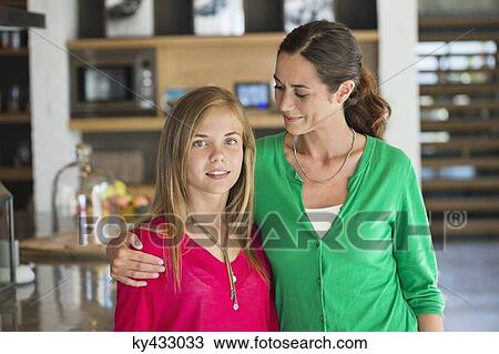 Stock Image - Close-up of a woman smiling with her daughter. Fotosearch