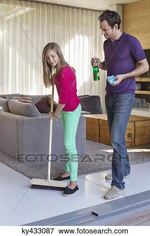 Girl cleaning floor with a mop beside her father View Large Photo Image Stock Photo - Girl cleaning floor with a mop beside her father. Fotosearch