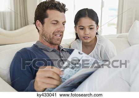 Man and his daughter reading a magazine View Large Photo Image Stock Image - Man and his daughter reading a magazine. Fotosearch