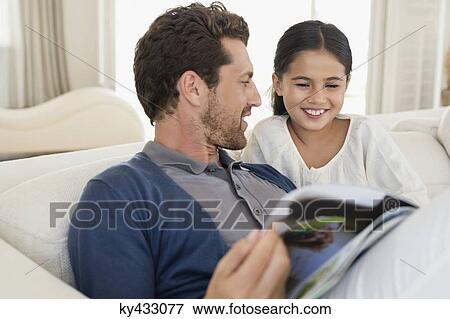 Man and his daughter reading a magazine View Large Photo Image Stock Photo - Man and his daughter reading a magazine. Fotosearch