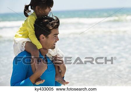 Man carrying his daughter on shoulders on the beach View Large Photo Image Stock Photography - Man carrying his daughter on shoulders on the beach. Fotosearch