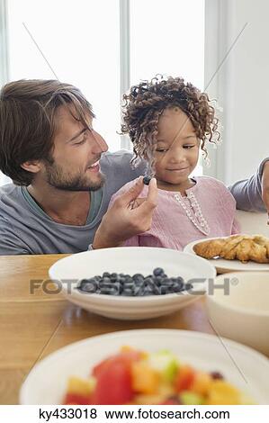 Man feeding his daughter View Large Photo Image Stock Photo - Man feeding his daughter. Fotosearch