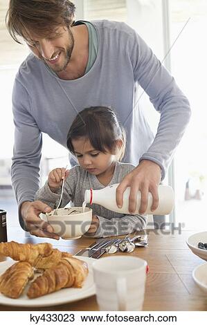 Man giving milk to his daughter View Large Photo Image Stock Image - Man giving milk to his daughter. Fotosearch