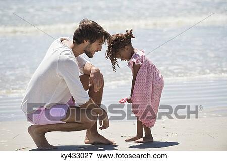 Man playing with his daughter the beach View Large Photo Image Stock Photo - Man playing with his daughter the beach. Fotosearch