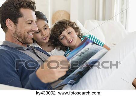 Stock Image - Man reading a magazine with his children. Fotosearch