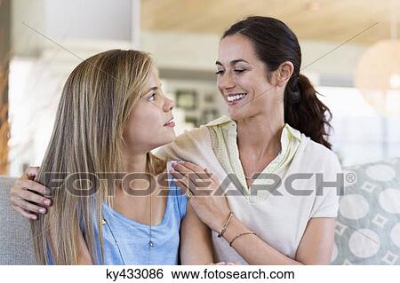 Stock Photograph - Mother and daughter looking at each other and smiling. Fotosearch