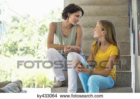 Mother and daughter sitting on steps and talking to each other View Large Photo Image Picture - Mother and daughter sitting on steps and talking to each other. Fotosearch