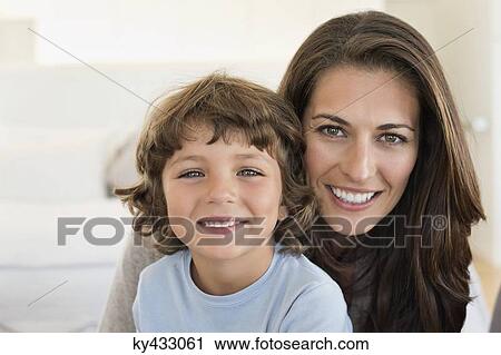 Portrait of a woman and her son smiling View Large Photo Image Stock Image - Portrait of a woman and her son smiling. Fotosearch