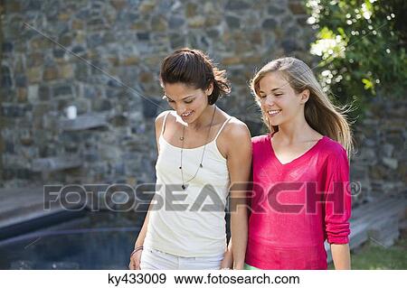 Smiling mother and daughter walking and holding each other's hands View Large Photo Image Stock Photo - Smiling mother and daughter walking and holding each other's hands. Fotosearch