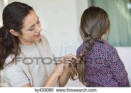 Smiling woman braiding her daughter's hair View Large Photo Image Stock Image - Smiling woman braiding her daughter's hair. Fotosearch
