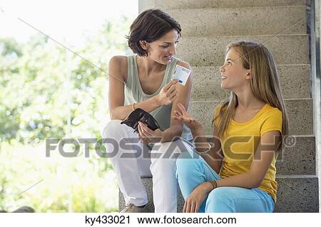 Woman giving pocket money to her daughter View Large Photo Image Stock Image - Woman giving pocket money to her daughter. Fotosearch
