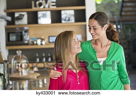 Woman smiling with her daughter at home View Large Photo Image Stock Image - Woman smiling with her daughter at home. Fotosearch
