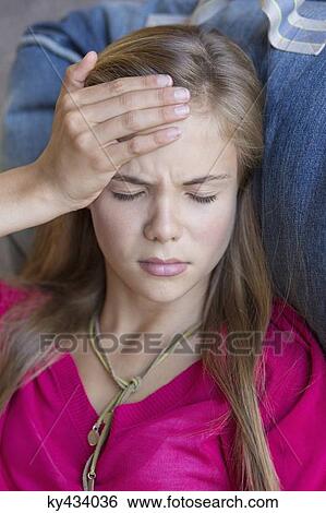 Close-up of a girl suffering from a headache View Large Photo Image Stock Photograph - Close-up of a girl suffering from a headache. Fotosearch