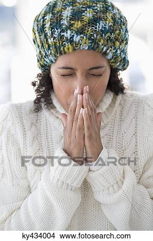 Picture - Close-up of a woman blowing her nose. Fotosearch