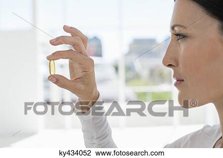 Close-up of a woman holding a capsule View Large Photo Image Stock Image - Close-up of a woman holding a capsule. Fotosearch