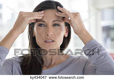 Stock Photo - Close-up of a woman suffering from a headache. Fotosearch