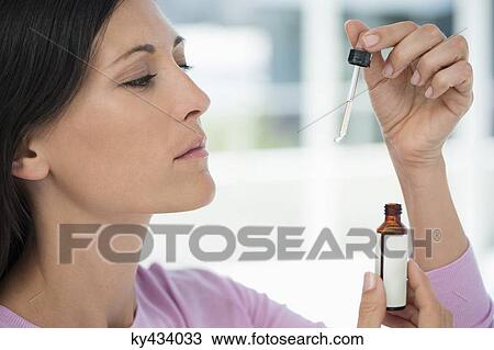 Close-up of a woman taking homeopathic medicine View Large Photo Image Stock Image - Close-up of a woman taking homeopathic medicine. Fotosearch