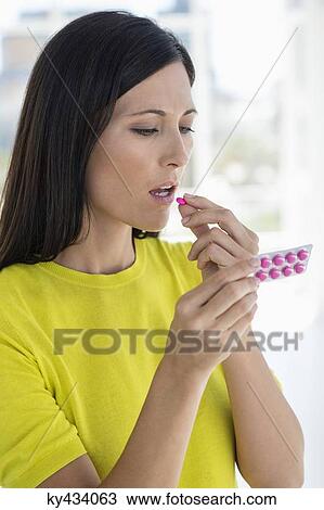 Stock Image - Close-up of a woman taking medicine. Fotosearch