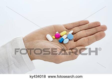 Stock Photo - Close-up of a woman's hand holding medicines. Fotosearch
