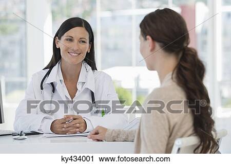 Stock Image - Female doctor discussing with a patient. Fotosearch
