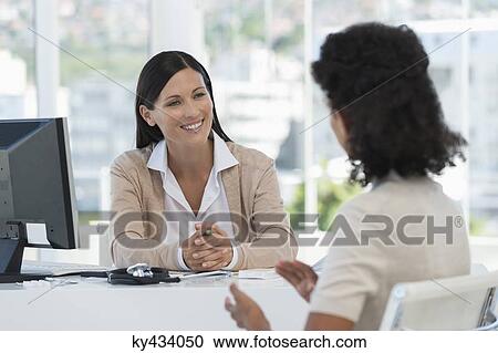 Stock Image - Female doctor discussing with a patient. Fotosearch