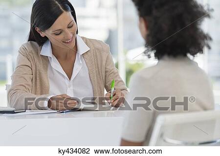 Female doctor sitting with a patient in her office View Large Photo Image Stock Image - Female doctor sitting with a patient in her office. Fotosearch