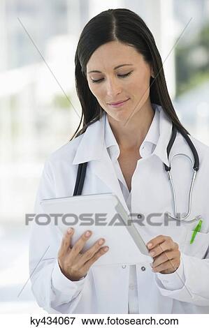 Female doctor using a digital tablet View Large Photo Image Stock Photo - Female doctor using a digital tablet. Fotosearch