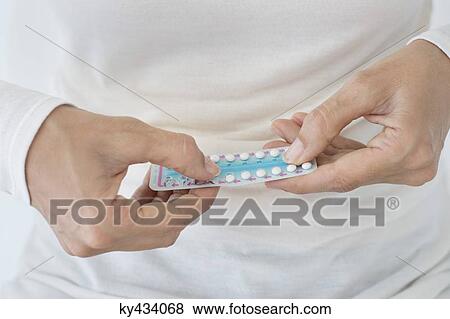 Mid section view of a woman holding a blister pack of contraceptive pills View Large Photo Image Stock Photo - Mid section view of a woman holding a blister pack of contraceptive pills. Fotosearch