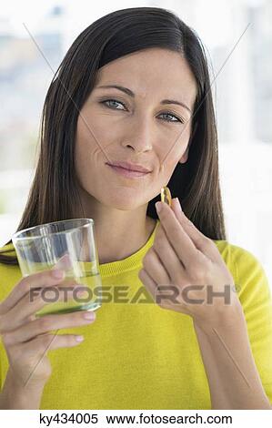 Stock Photography - Portrait of a woman taking medicine. Fotosearch