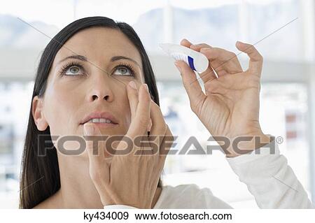 Woman applying eye drops into eye View Large Photo Image Stock Photo - Woman applying eye drops into eye. Fotosearch